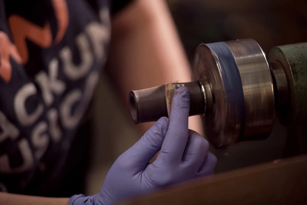 Person wearing gloves holding a mouthpiece with a blurred background