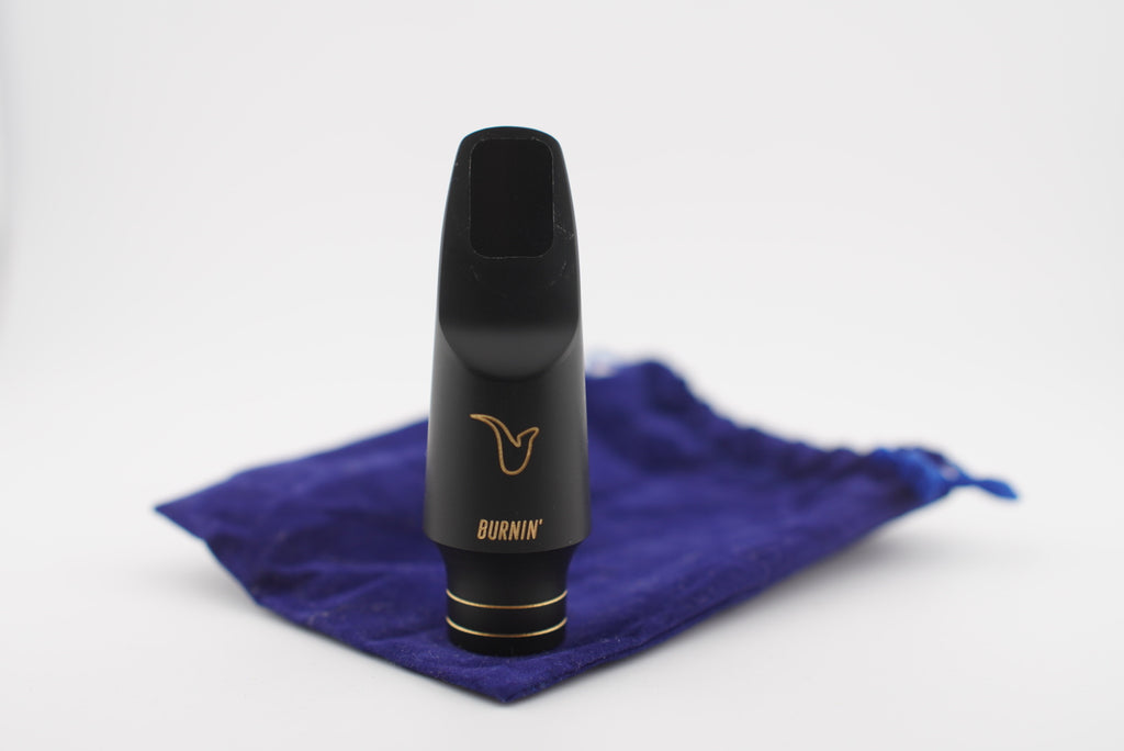 Black saxophone mouthpiece with 'BURNIN' branding on a blue cloth against a white background