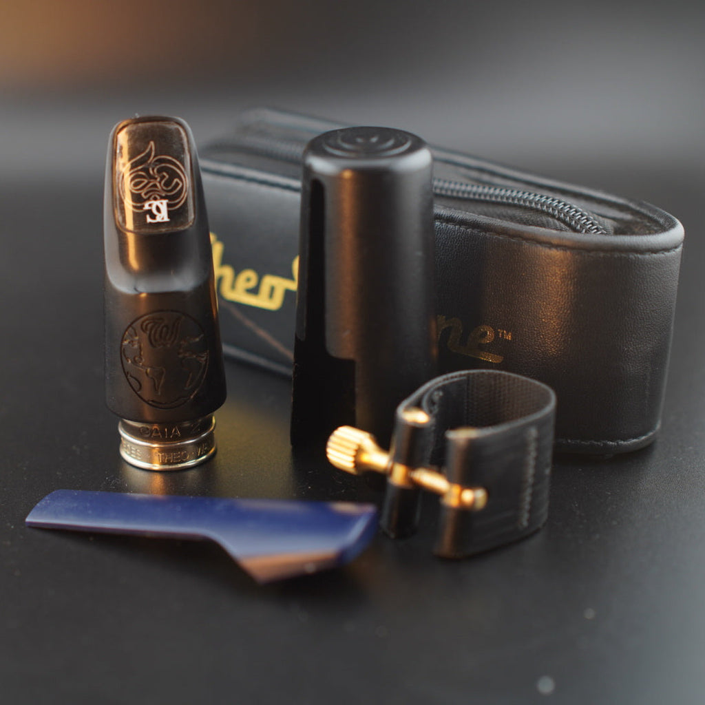 alto saxophone mouthpiece with leather case on a dark surface