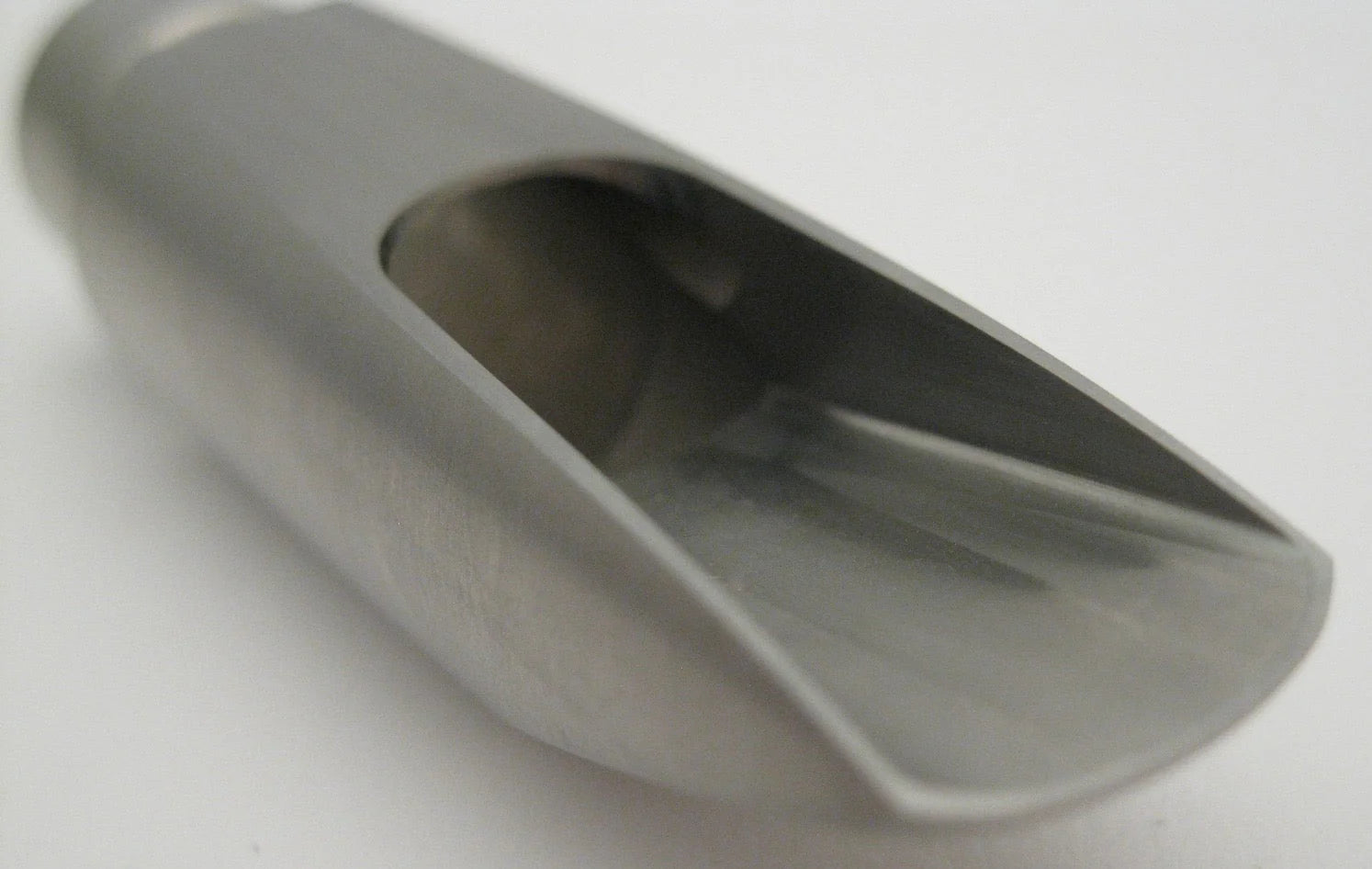 Metallic saxophone scoop baffle on a white background